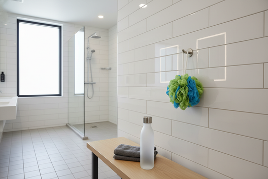 The African Net Sponge in a gym shower, shown as the best tool for a post-workout routine to prevent body acne.